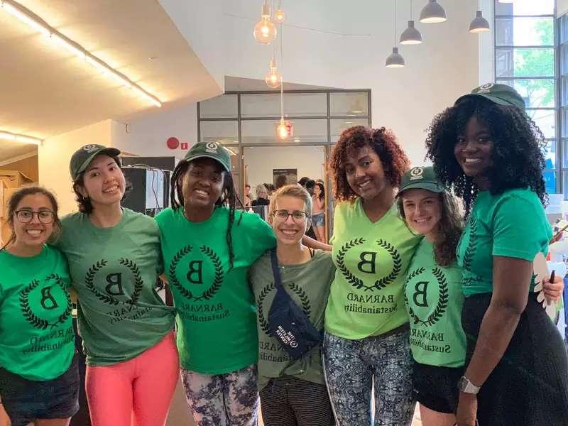 7 young women in green Barnard 可持续性 shirts with their arms around each other